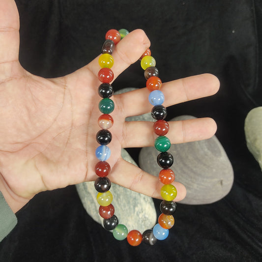 Multicolored beaded bracelet on a hand with a dark background
