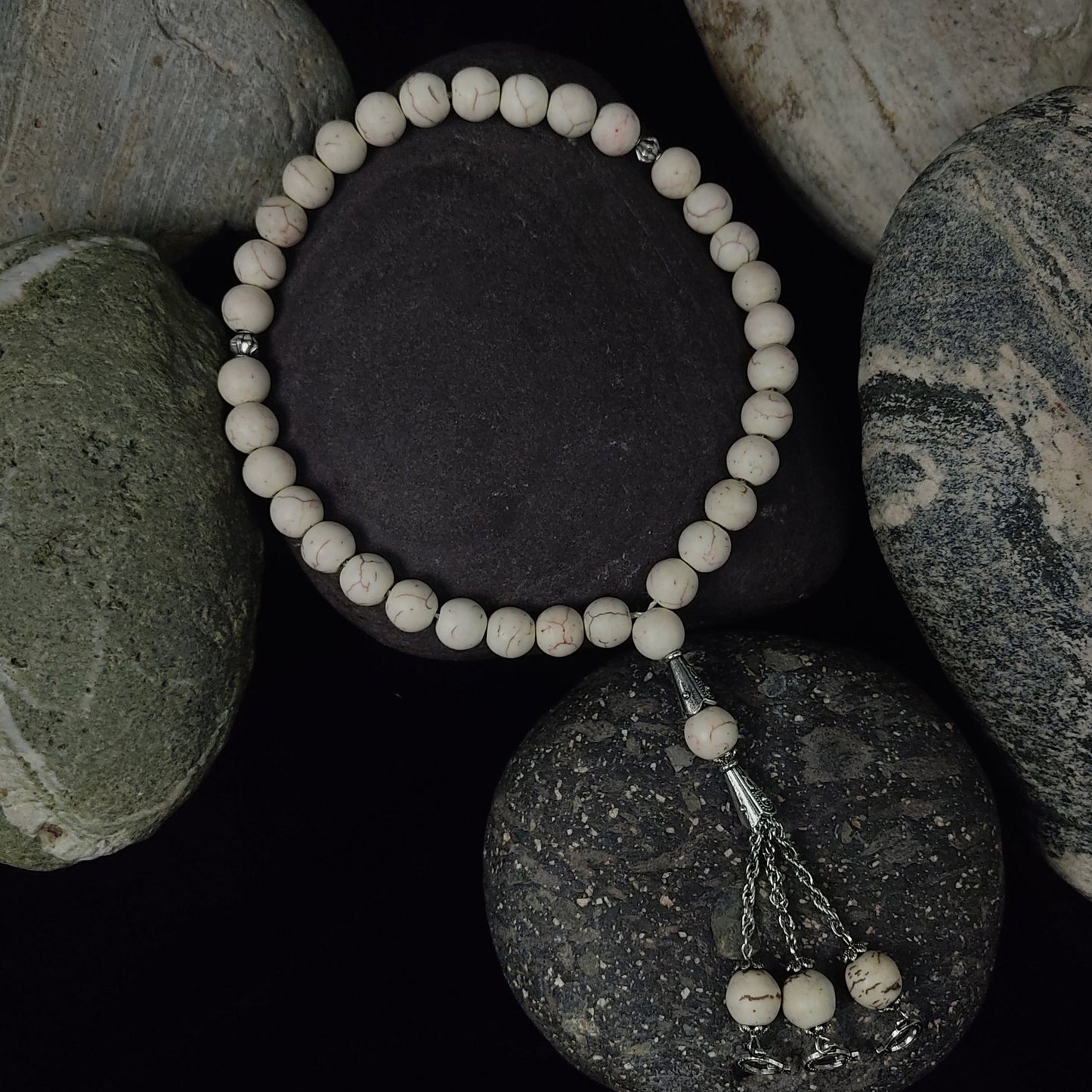 Beaded bracelet on a stack of stones with a dark background