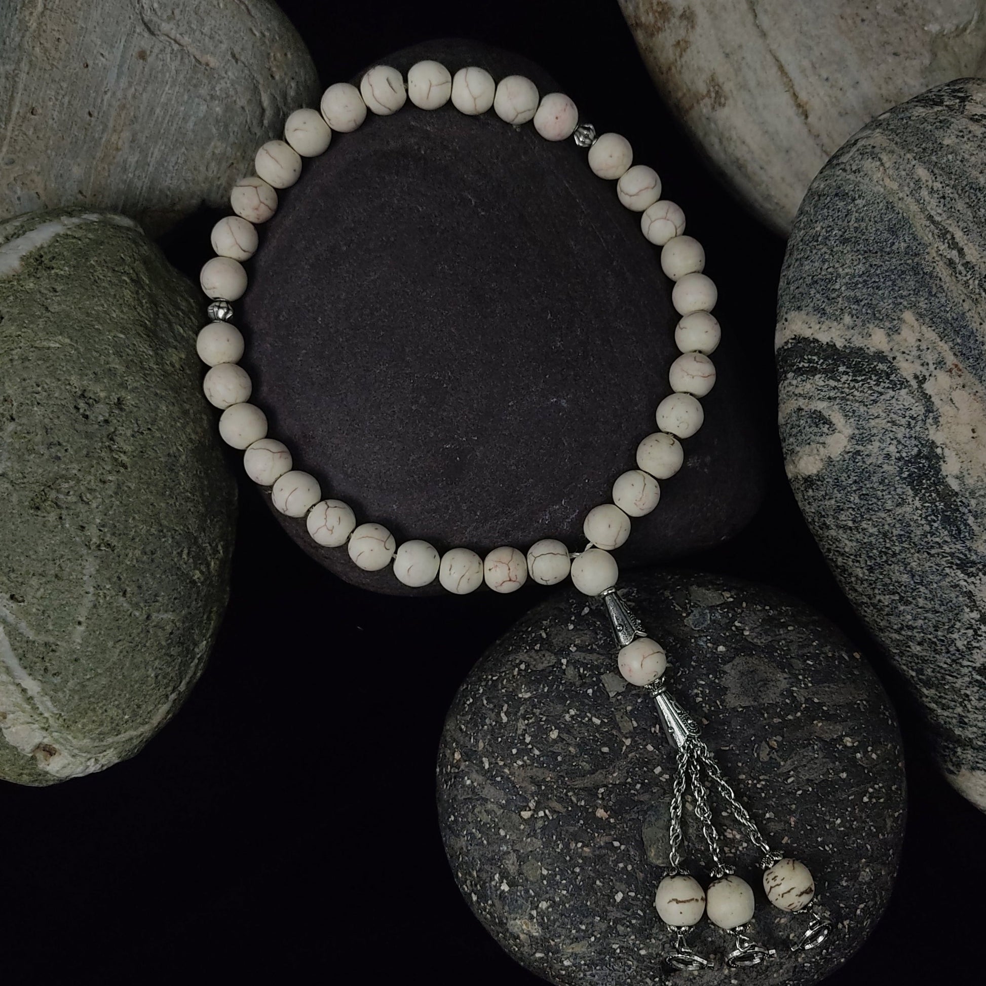 Beaded bracelet on a stack of stones with a dark background